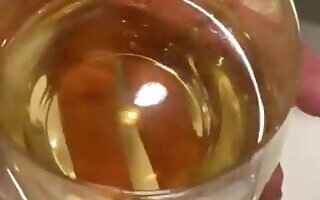 Pretty readhead pees into a glass